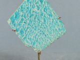 une petite sculpture représentant un diamant bleu sur un socle en marbre
