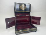 a black and red bed with a gold decoration on it