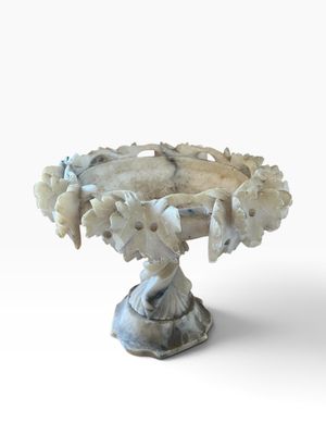 a white pedestal with a bunch of flowers on it