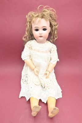 a small doll that is sitting on a pink surface