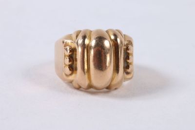 gros plan d'une bague en or sur une surface blanche