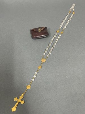 a close up of a rosary and a wallet on a table