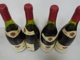 four bottles of wine are lined up on a white surface