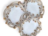 three white and gold plates with gold designs on them on a white surface
