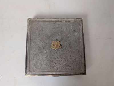 a small metal box with a piece of gold in it