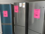 three refrigerators in a room with pink stickers on them