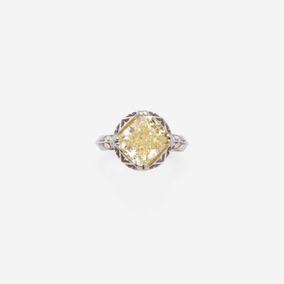 une bague raffinée sertie d'un diamant jaune, avec un anneau en filigrane