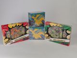 trois boîtes de cartes à collectionner Pokémon empilées les unes sur les autres