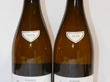deux bouteilles de vin posées sur une table l'une à côté de l'autre