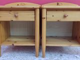two wooden nightstands with drawers on them against a pink wall