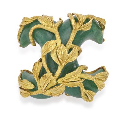 une image représentant une broche « broche » dorée et verte ornée de feuilles