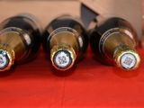 several bottles of wine are lined up on a red table