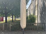 un grand parapluie fixé à un mât devant un immeuble