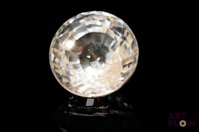 une image représentant une boule de cristal transparente posée sur une surface noire