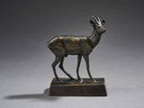 statue en bronze représentant un cerf debout sur un socle en bois