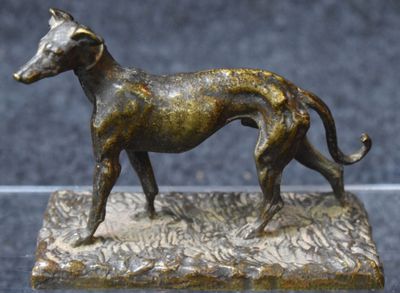 statue en bronze représentant un chien, posée sur un socle posé sur une table