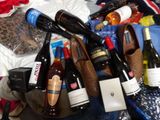 a pile of bottles of wine and shoes on a bed