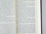 an open book on a table with a red handle on it
