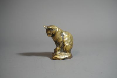 un gros plan sur une figurine représentant un chat posée sur une surface blanche