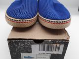 les chaussures bleues sont posées sur une boîte, sur une surface blanche