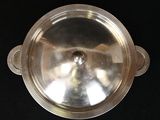 a silver plate on a black table with a black background