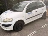 une petite voiture blanche garée dans un parking