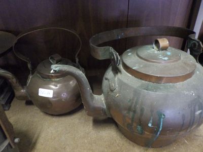 two old teapots sitting next to each other on the floor