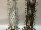 two tall wooden sticks are stacked on top of each other on a white surface