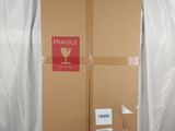 a cardboard box sitting on top of a bed with a fragile label on it