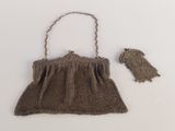an old brown purse with a chain hanging from it ' s side