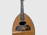 an old wooden guitar with a black and white design on the neck