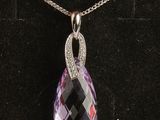 un pendentif en améthyste et diamant posé sur un fond de velours noir