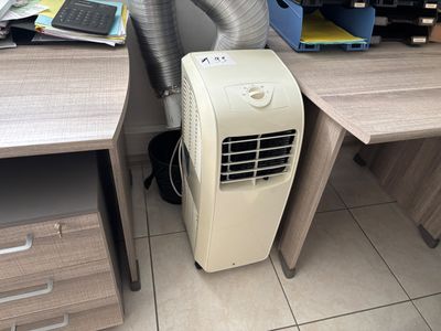 a small air conditioner sitting on a desk next to a computer