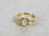 a close up of a gold ring with a diamond in the center