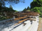 a large pile of steel rods sitting on top of a cement slab