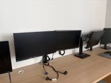 three computer monitors sitting on a desk next to each other