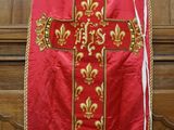 une image représentant un gilet rouge et doré orné d'une croix