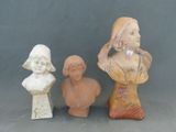 trois statues de femmes assises côte à côte sur une table