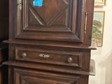 a tall wooden cabinet in the corner of a room