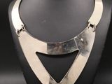 un gros plan d'un collier en argent sur un mannequin
