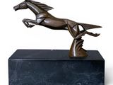 bronze sculpture of a horse running on a black marble base
