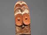 a wooden mask with two eyes and a mouth