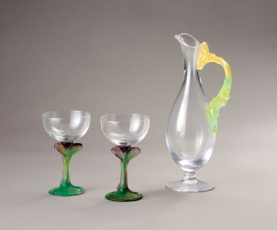 three wine glasses and a pitcher sitting next to each other