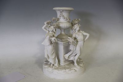 un vase blanc surmonté d'une statuette