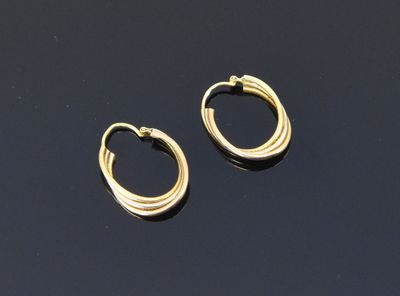 a pair of gold hoop earrings on a black surface