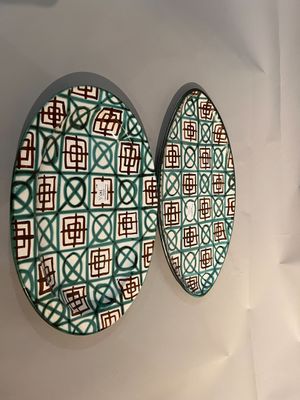 Deux assiettes décoratives sont accrochées au mur d'une pièce.