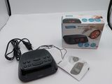 a black alarm clock sitting on a table next to a box