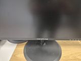 a computer monitor sitting on top of a wooden desk