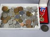 une boîte remplie de pièces et une médaille posées sur une table