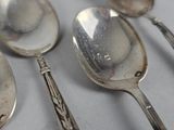 five spoons and two spoons sitting on a table